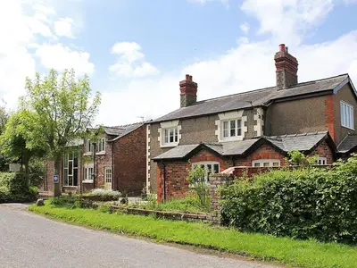 an old brick house on the side of a road at The Dairy in Burscough