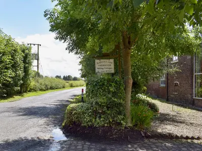 a sign on a tree on the side of a road at The Shippon in Burscough