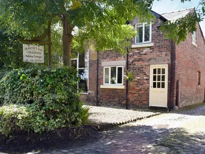 a brick building with a white door and a tree at The Granary in Burscough