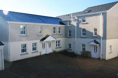 two buildings with white doors and a courtyard at 5 Laurel Court in Ulverston