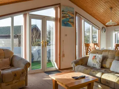 a living room with two couches and a table at Tranquillity in Millom