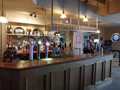 a bar with a lot of bottles of alcohol at Ye Olde Fighting Cocks in Arnside