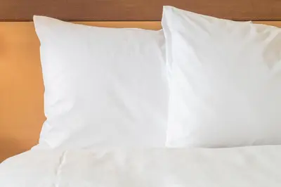a bed with white sheets and pillows on it at Holiday Inn Express Preston South by IHG in Preston