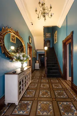 a hallway with blue walls and a staircase with a mirror at Beach House in Lytham St Annes