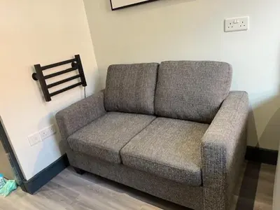 a couch in the corner of a room at The Anfield Rooms in Liverpool