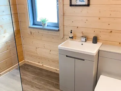 a bathroom with a white sink and a window at Larch Lodge - Uk30009 in Lindal in Furness