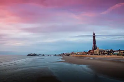 a view of a beach with a pier and a lighthouse at 2 Bedrooms Sleeps 7 Near Top Blackpool Attractions in Blackpool