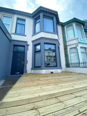 a house with a wooden deck in front of it at Chelsea Suite Sasco Apartments in Blackpool