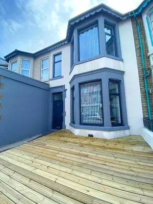 a large house with a wooden deck in front of it at Chelsea Suite Sasco Apartments in Blackpool