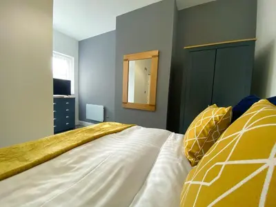 a bedroom with a large bed and a mirror at Mayfair Suite - 3x Bathrooms Close to Seafront in Blackpool