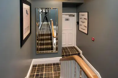 a hallway with a staircase with a mirror and a stair case at Blackbird Luxury Accommodation Studio Room 9 in Blackpool