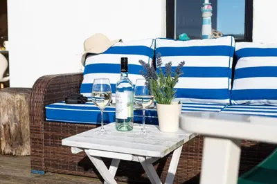 a table with two glasses of wine on a couch at Finest Retreats - Walney Island Lighthouse in Rampside