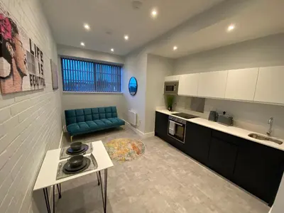 a kitchen with a blue couch in a room at Kempston Suites Liverpool Apartment 4 in Liverpool