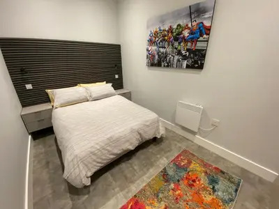 a bedroom with a bed and a painting on the wall at Kempston Suites Liverpool Apartment 5 in Liverpool