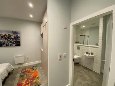 a bathroom with a bed and a sink and a mirror at Kempston Suites Liverpool Apartment 5 in Liverpool