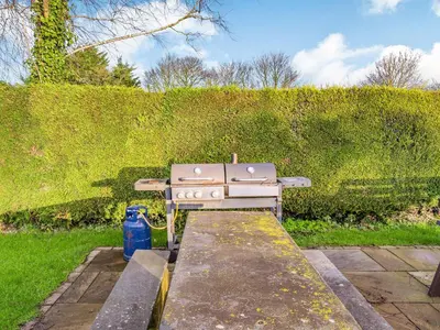 a gas stove sitting on a stone slab in a garden at The Barn in Poulton le Fylde