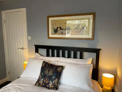 a bed with white pillows and a picture on the wall at Tranquil 3 bedroom town house with Sky Glass in Thornton