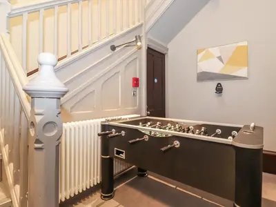 a staircase with a pool table in a room at William Tower Suite Stone Cross Mansion in Ulverston