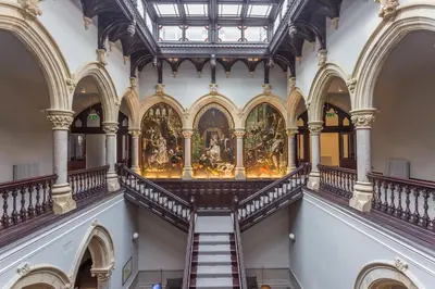 a staircase in a building with a painting on the wall at The Alfred Suite Stone Cross Mansion in Ulverston