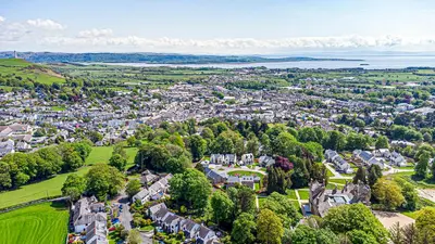 an aerial view of a town with trees and houses at The Alfred Suite Stone Cross Mansion in Ulverston