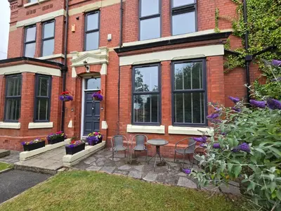 a brick house with a table and chairs in the yard at Victorian Renovation Room 1 in Liverpool