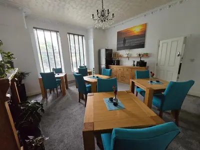 a dining room with wooden tables and blue chairs at Victorian Renovation Room 4 in Liverpool