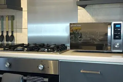 a kitchen with a stove and a microwave at Stylish Apartment in City Centre with Parking in Preston