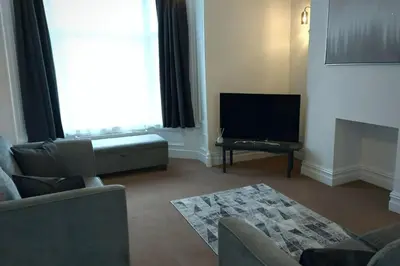 a living room with a couch and a flat screen tv at Stylish Apartment in City Centre with Parking in Preston