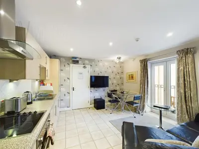 a kitchen and living room with a couch and a table at Sandbanks Suite in Blackpool