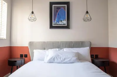 a bedroom with a white bed with two stools at Withnell Stays - Apartment Four - Ground Floor in Blackpool