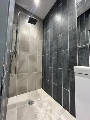 a bathroom with a shower with a tile wall at Olivia Rose Suite by Sasco Apartments in Blackpool