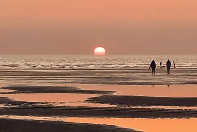 a group of people walking on the beach at sunset at Beauview Brand New For 2023 Wi-Fi and Smart TV in Millom
