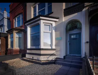 a house with a blue door on a street at Coral Boutique Apartment 1 in Blackpool