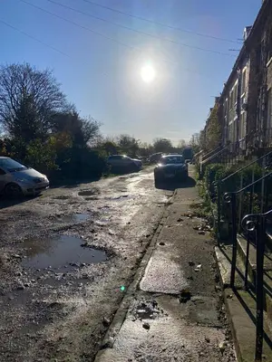 a dirty street with cars parked on it at The Snug on Hornby in Morecambe