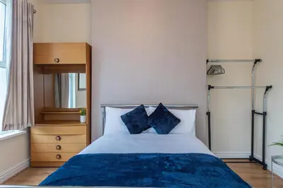 a bedroom with a bed with two blue pillows at 10 Guests - Free Parking - City Centre in Liverpool