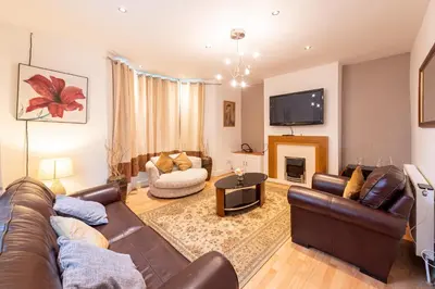 a living room with a leather couch and a fireplace at 10 Guests - Free Parking - City Centre in Liverpool